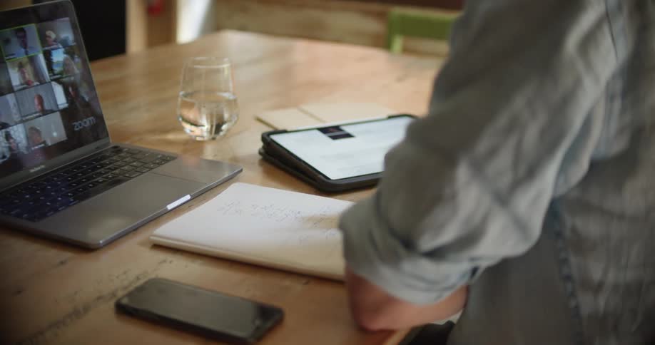 A man sitting at a laptop talking to others