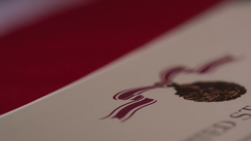A military certificate is framed against red paper