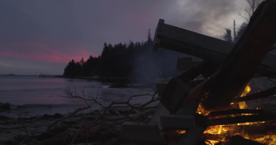 A campfire on a beach at dusk