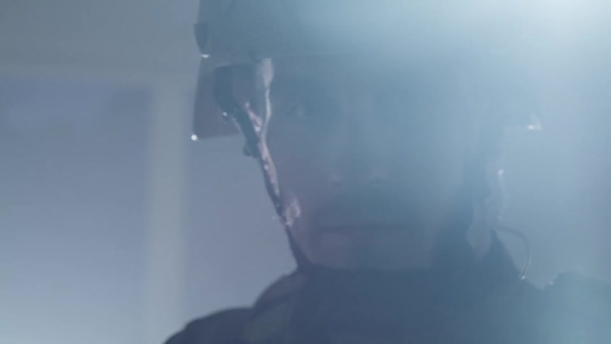 A man in a military uniform with a helmet in a room with smoke