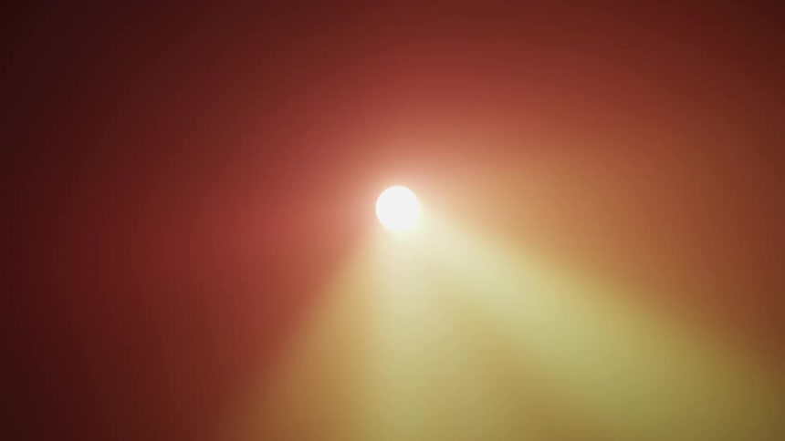 Colorful reflection of a spotlight over the smoke filling a dark room