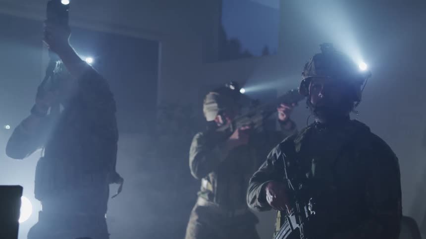 A group of people in the military pointing guns around