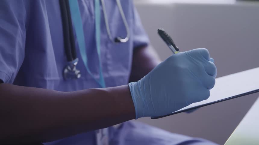 A doctor is writing on a pad