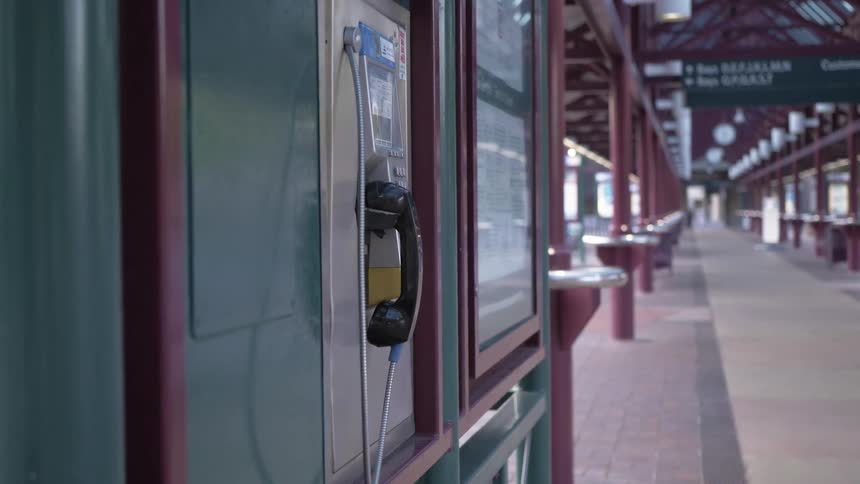 Pay phone on a wall in a wide open hallway
