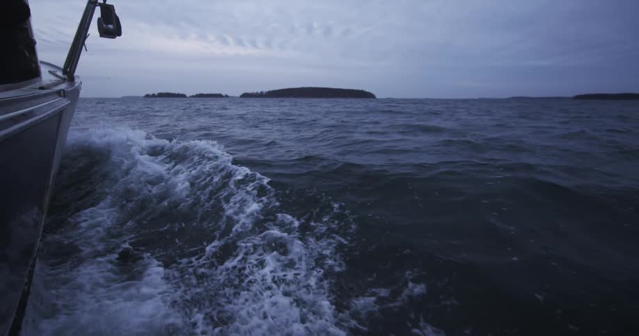 A boat and the wake that it has created on an overcast morning