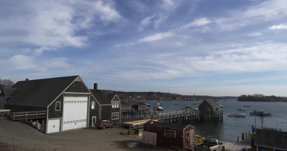 Boats are all still in the water by a pier