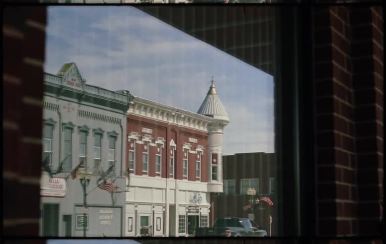 A row of buildings reflected in the window of a building on the other side of the road