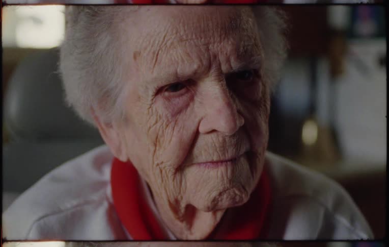 An elderly man is sitting in a living room