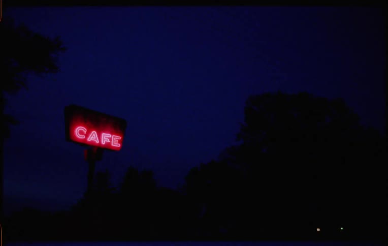 A neon sign flashing at a cafe at night
