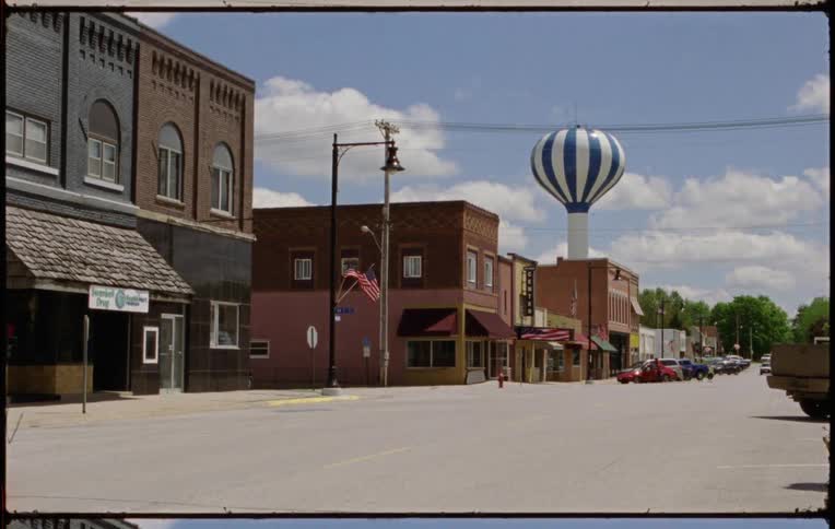 Vehicles are parked in front of businesses in a small town