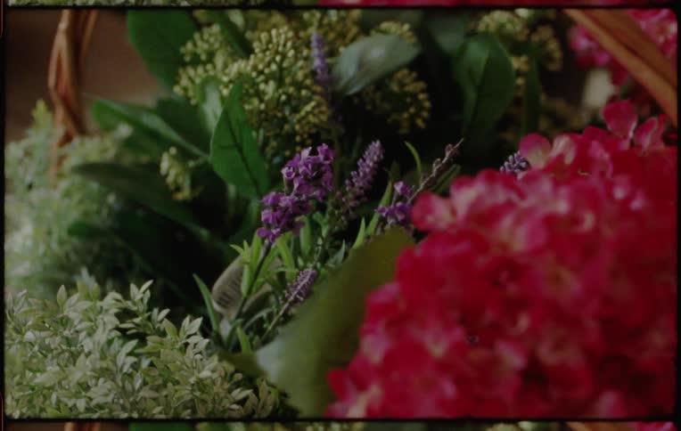 A beautiful flower arrangement in a basket is carried and carefully set down