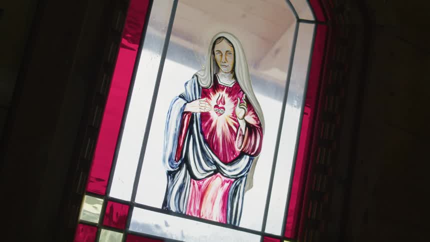 A stained glass window of the blessed virgin mary