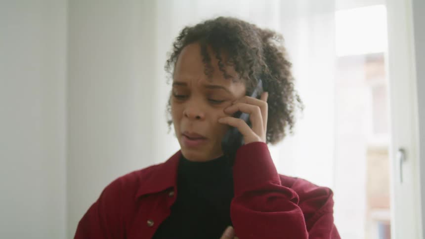 A woman is walking and talking on her phone