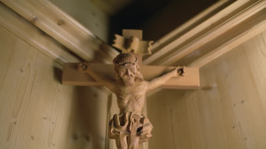 A wooden crucifix of the lord jesus christ in the corner of a room