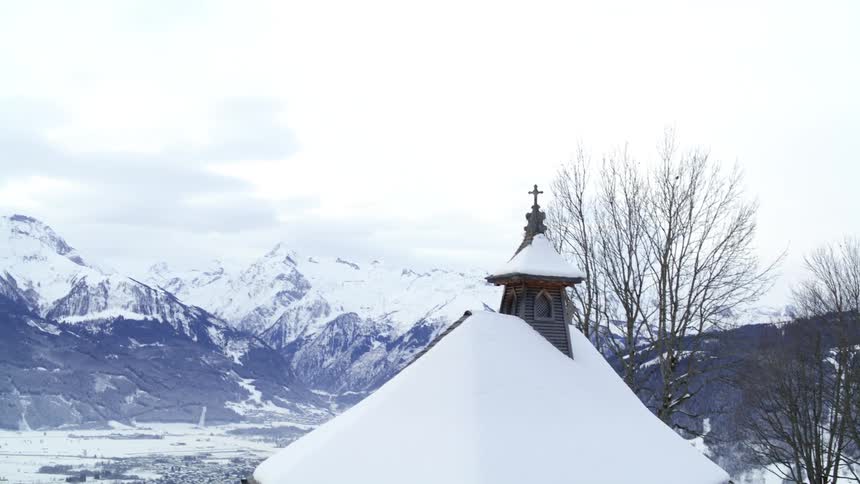 Small church coverd in snow near a lake in the mountains at winter