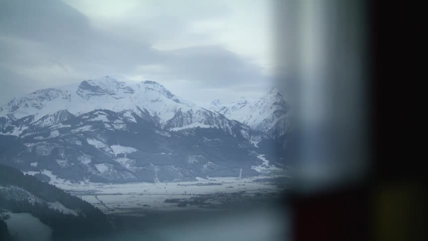 The mountains through the window are covered with snow