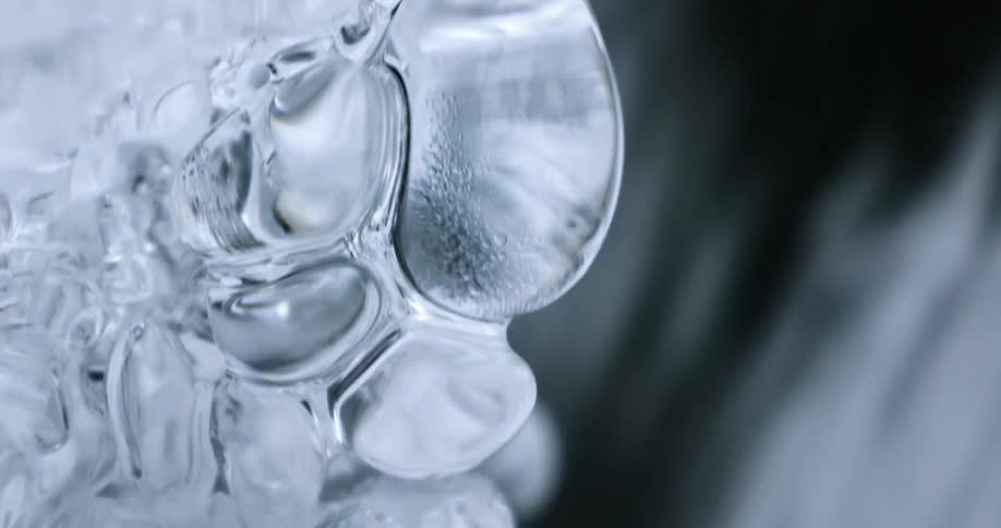 Water flows behind a chunk of shimmering ice