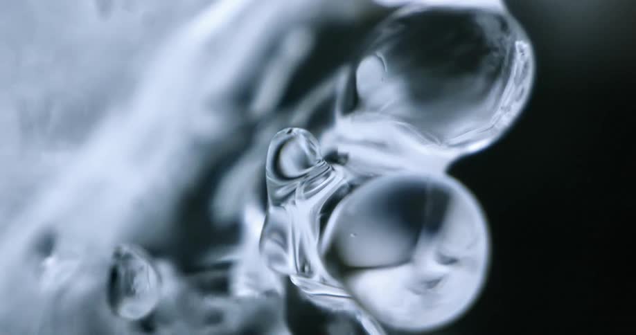 Water flows over ice causing it to shimmer against black