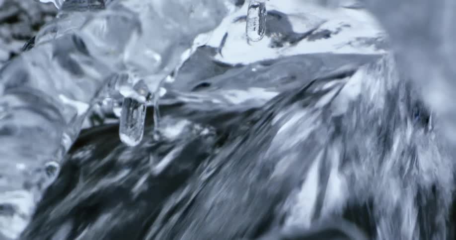 Water pouring out from underneath melting ice outdoors