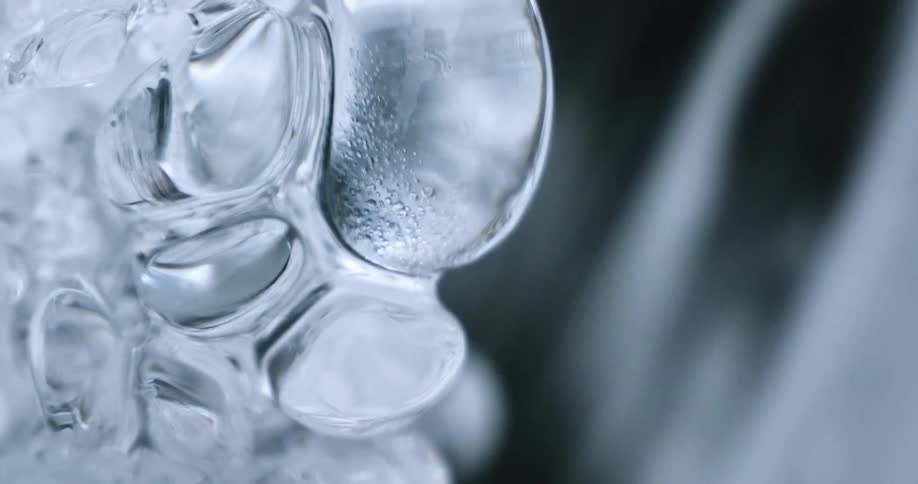 A piece of ice with circle shapes inside of it melting