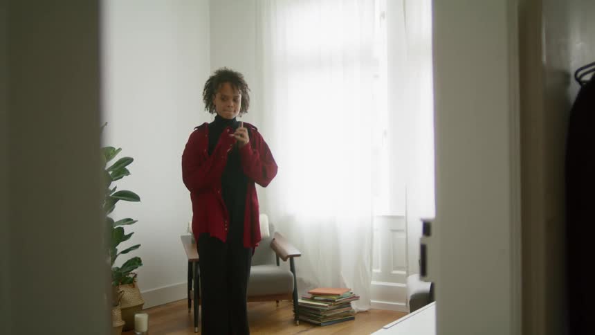 A woman at home talks on her cell phone and gets all excited