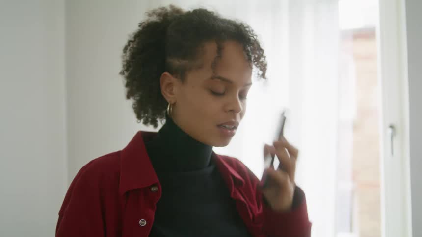 A woman angrily talks on her smartphone before hanging up and shaking her head in frustration