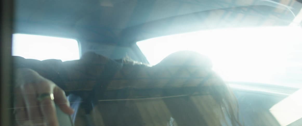 A woman in the backseat of a vehicle dancing to music
