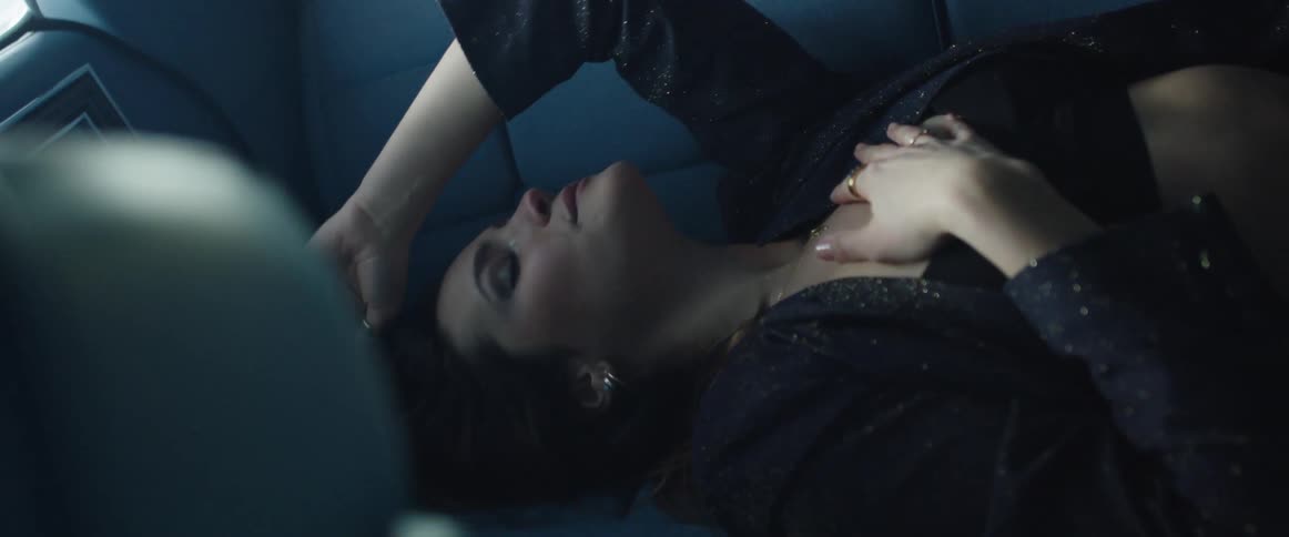 A woman is laying in the backseat of the vehicle