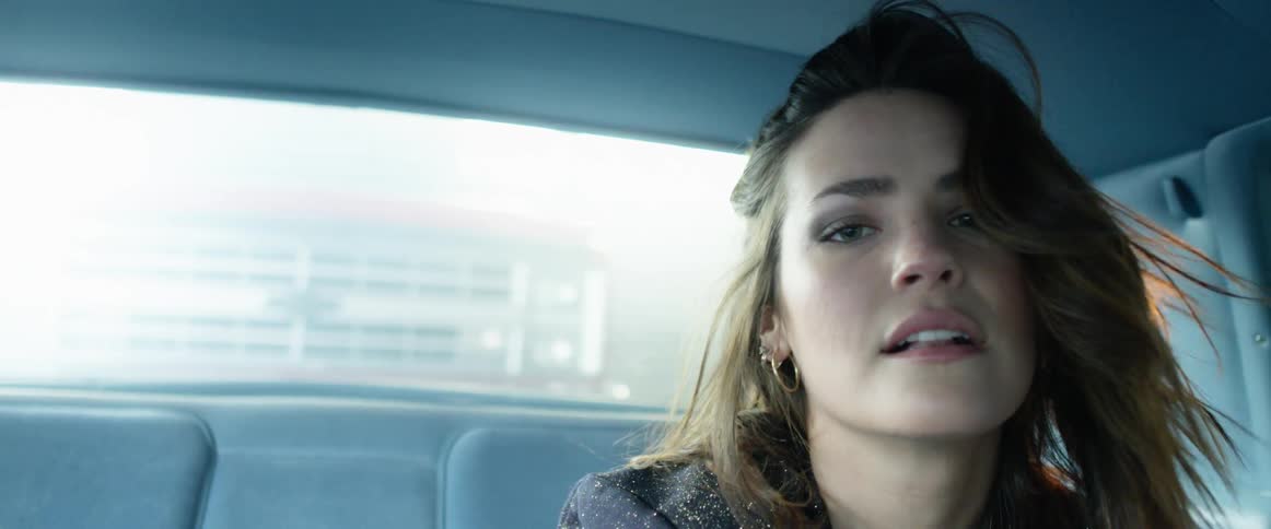 A woman is dancing in the back of her car