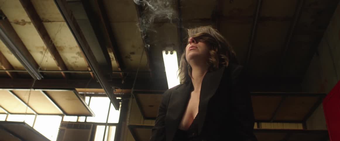 A woman is smoking in the large room