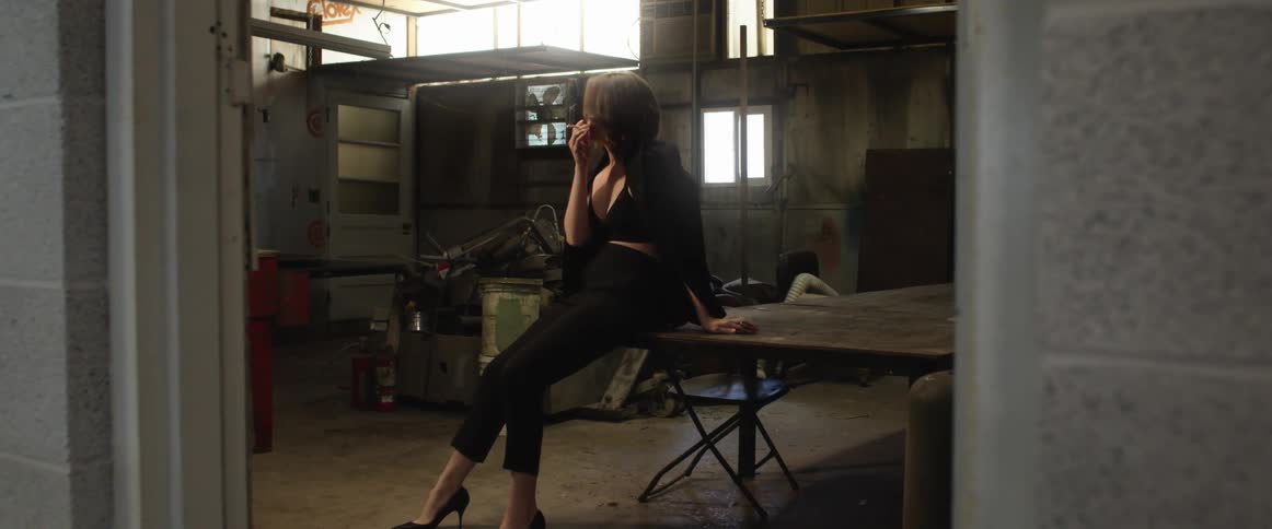 Woman sitting on table lights a cigarette and smokes