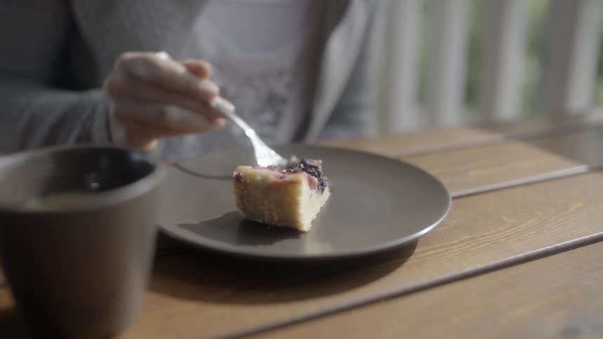 A woman uses a fork to get a bite of cobbler