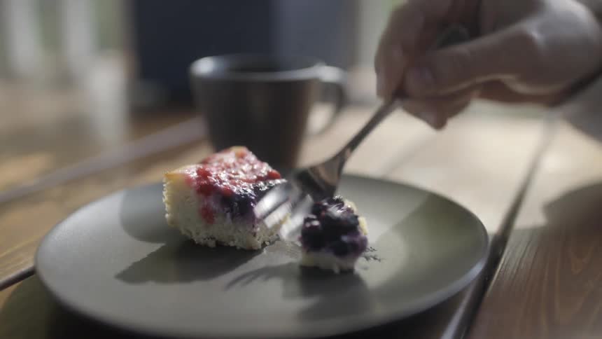 A person picks up a piece of cake with a fork