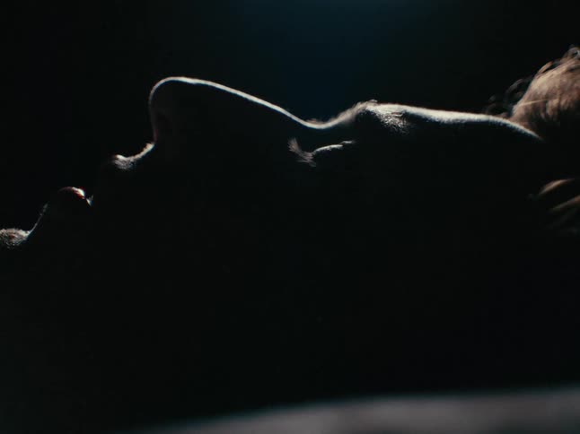 A man stares at the ceiling while lying down and decides to get up