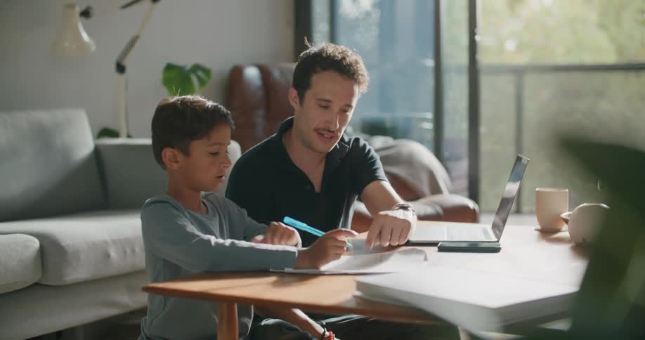 A father is helping his son with homework