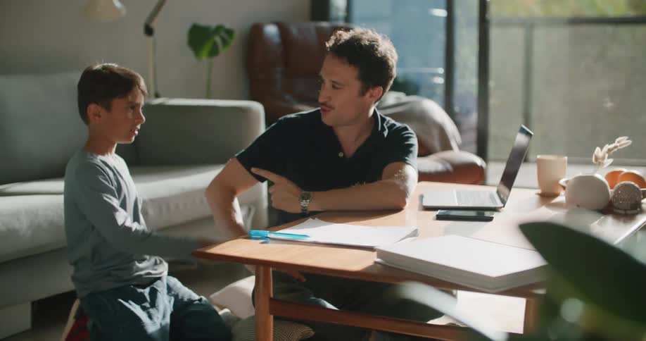 A father talks with his son in the living room