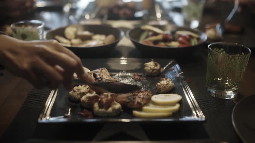 A person cuts meat on a plate