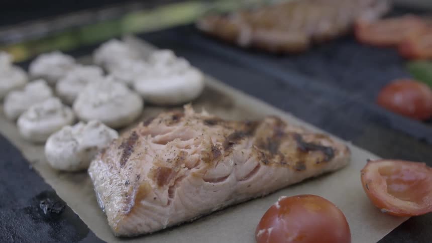 Salmon and vegetables being cooked on a grill