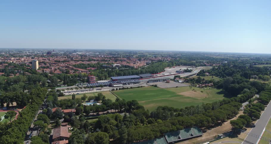 Aerial view of a race track near a small town under a blue sky