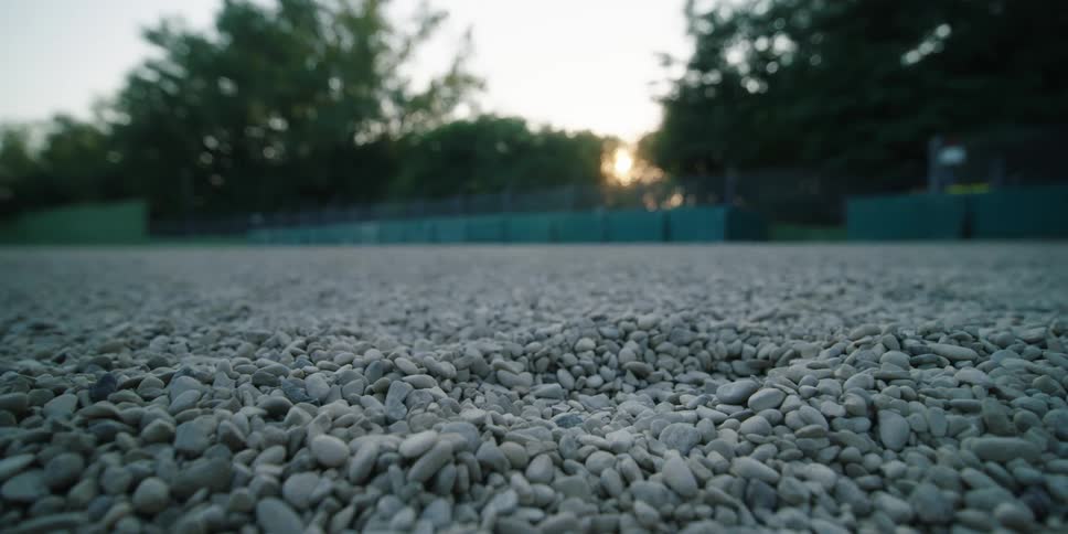 An open lot is filled with round gravel