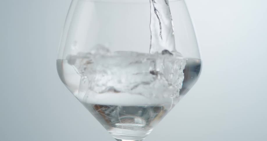 Water being poured into a stemmed glass