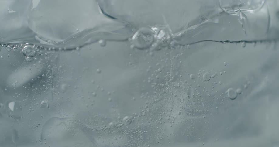 Bubbles in a drink rise up around ice