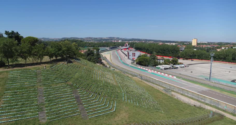 Aerial view of a race track near a small town under a clear blue sky