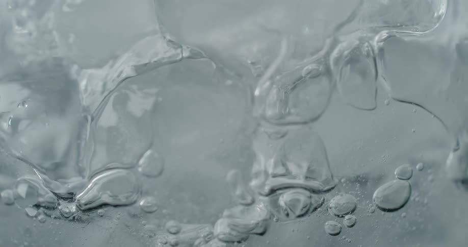 Water pouring over ice cubes and bubbles are rising up