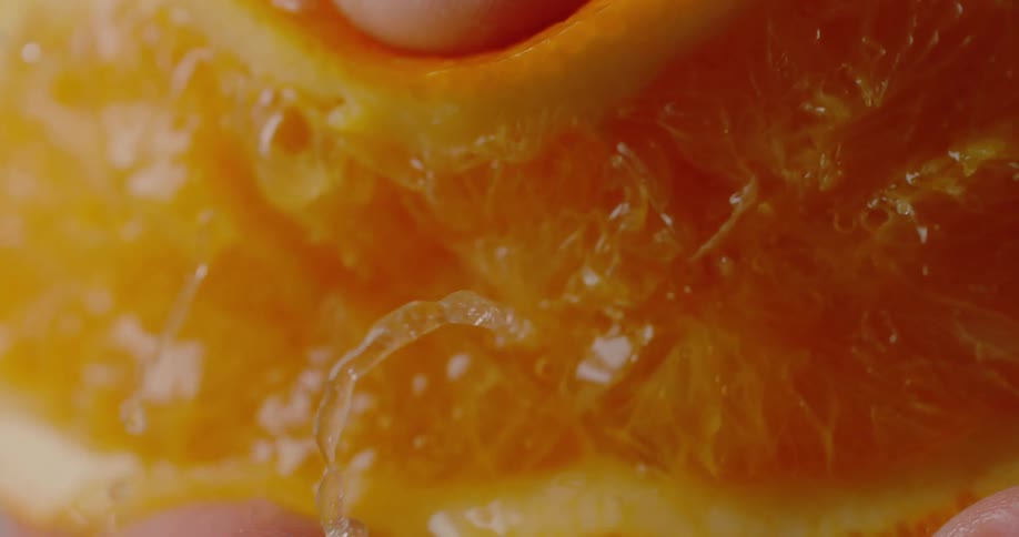 A person is squeezing an orange indoors