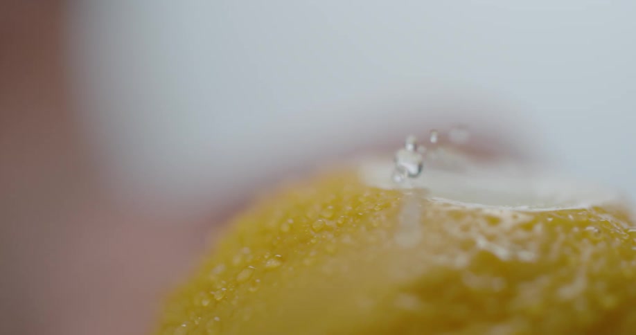 A knife cutting the top off of a lemon