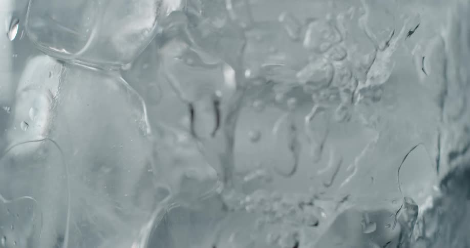 Water being poured into a glass of ice