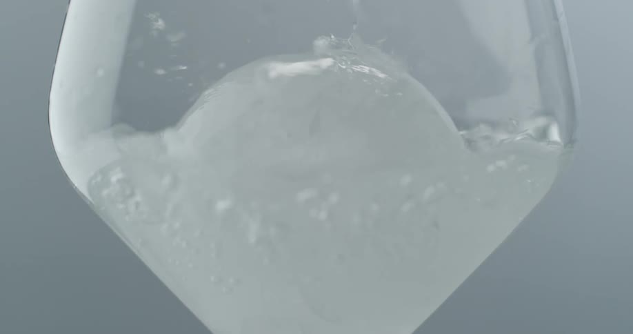 Water being poured into a glass with ice in it