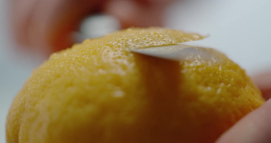 Person slices peel off citrus