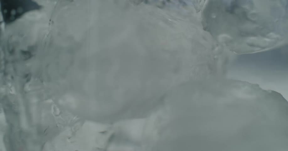 Ice cubes falling and water pouring over them